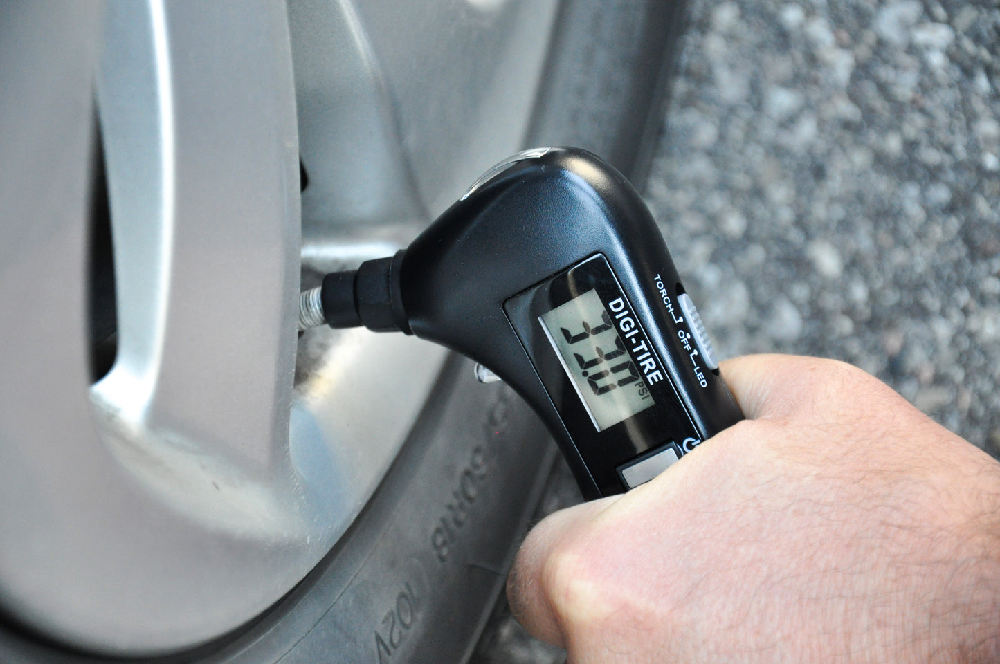 Car gift tool being used to check tire PSI, Best car gift tool